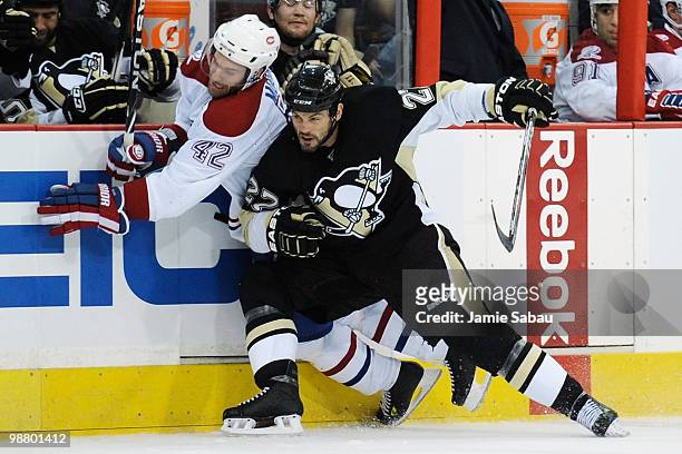 Craig Adams of the Pittsburgh Penguins checks Dominic Moore of the Montreal Canadiens along the side boards in Game Two of the Eastern Conference...