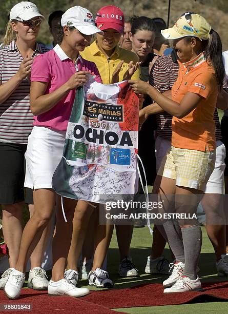 Japanese golfer Ai Miyazato gives a caddie vest with signatures to Mexican Golfer Lorena Ochoa --who has recently announced her retirement-- after...