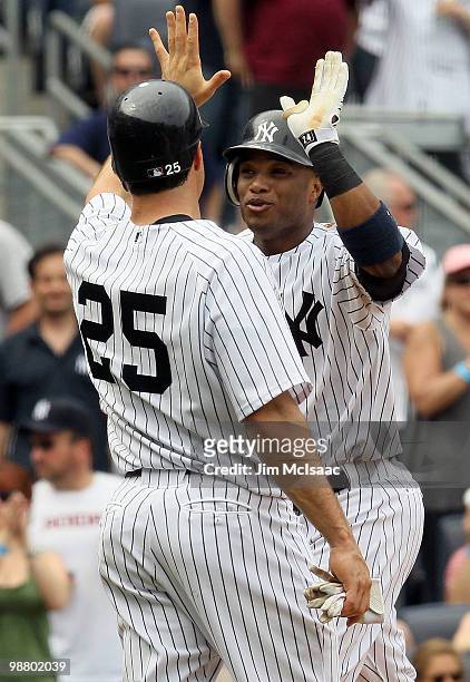 Robinson Cano of the New York Yankees celebrates his fifth inning three run home run against the Chicago White Sox with teammate Mark Teixeira on May...