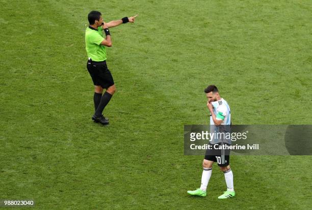 Referee Alireza Faghani gives instructions as Lionel Messi of Argentina looks dejected during the 2018 FIFA World Cup Russia Round of 16 match...