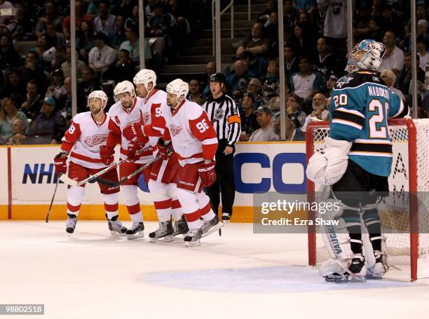 Pavel Datsyuk of the Detroit Red Wings is congratulated by teammates after he scored a goal on Evgeni Nabokov of the San Jose Sharks, who is watching...