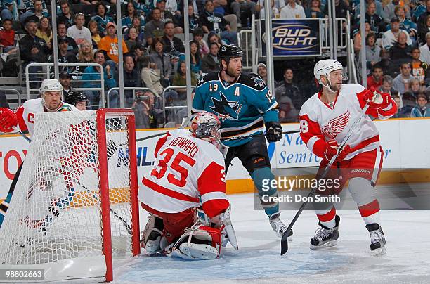 Jimmy Howard, Brian Rafalski and Nicklas Lidstrom of the Detroit Red Wings defend the net against Joe Thornton of the San Jose Sharks in Game Two of...
