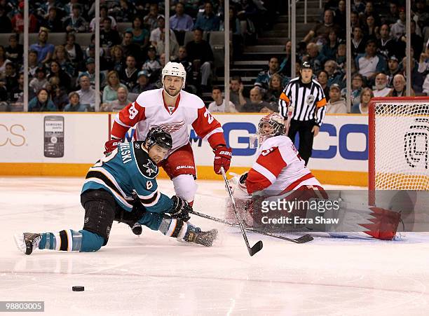 Joe Pavelski of the San Jose Sharks is defended by Brian Rafalski and goalie Jimmy Howard of the Detroit Red Wings in Game Two of the Western...