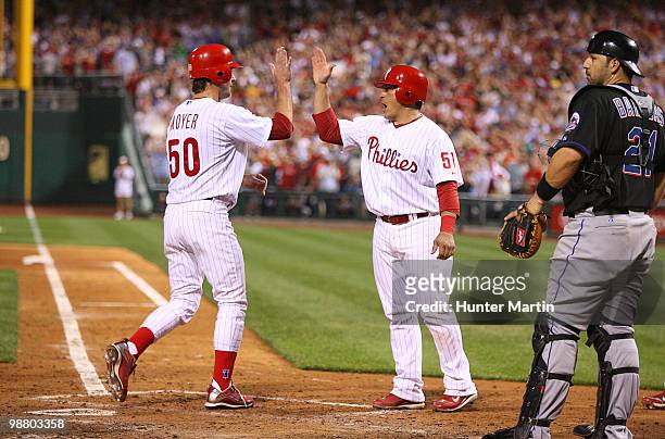 Starting pitcher Jamie Moyer of the Philadelphia Phillies is greeted by catcher Carlos Ruiz after scoring a run during a game against the New York...