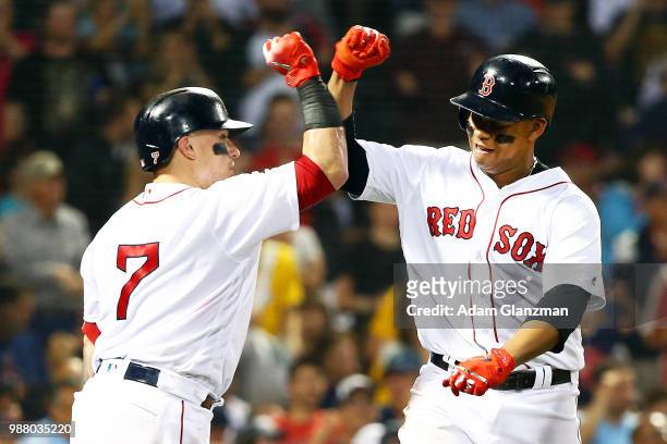 Rafael Devers high fives Christian Vazquez of the Boston Red Sox after hitting a solo home run in the fifth inning of a game against the Los Angeles...