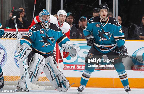 Tomas Holmstrom of the Detroit Red Wings watches the play behind Evgeni Nabokov and Kent Huskins of the San Jose Sharks in Game Two of the Western...