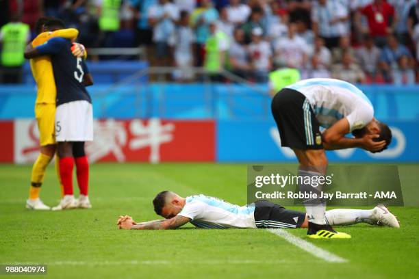 Lucas Biglia of Argentina and Nicolas Otamendi of Argentina look dejected at the end of the 2018 FIFA World Cup Russia Round of 16 match between...