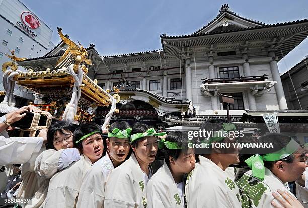 Men carry a portable shrine in front of Kabukiza theatre, home of Japan's traditional kabuki drama that closed its doors last Friday to be demolished...