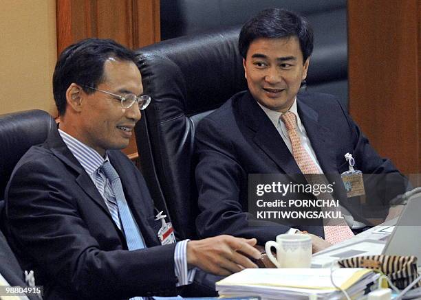 Thai Prime Minister Abhisit Vejjajiva talks with Finance Minister Korn Chatikavanij during a senate meeting to discuss the political unrest at...