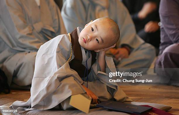 Child has his hair shaved off during the 'Children Becoming Buddhist Monks' ceremony forthcoming buddha's birthday at a Chogye temple on May 3, 2010...