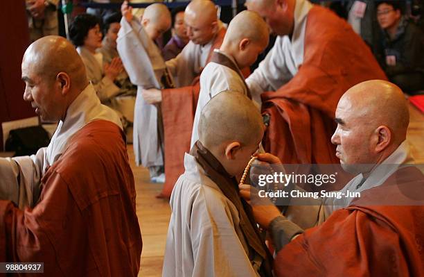 Children are dressed in robes by monks during the 'Children Becoming Buddhist Monks' ceremony forthcoming buddha's birthday at a Chogye temple on May...