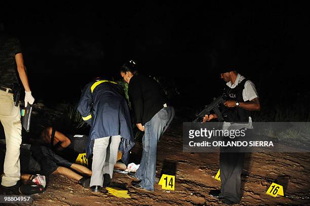 Agents of the Directorate General of Criminal Investigation, remain at the crime scene where the bodies of six young men who were shot dead after...