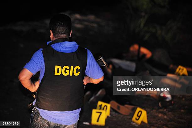 An agent of the Directorate General of Criminal Investigation, remain at the crime scene where the bodies of six young men who were shot dead after...