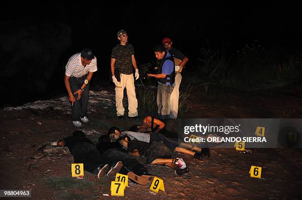 Agents of the Directorate General of Criminal Investigation, remain at the crime scene where the bodies of six young men who were shot dead after...