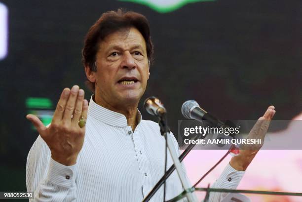 Pakistani cricketer-turned-politician and head of the Pakistan Tehreek-i-Insaf Imran Khan gestures as he delivers a speech during an election...