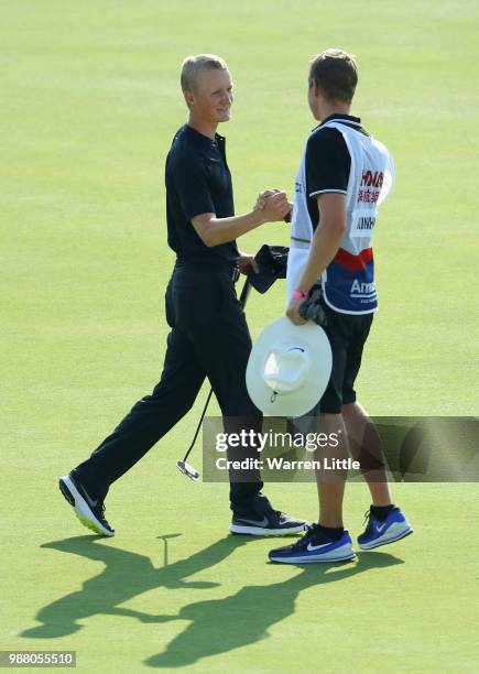 Marcus Kinhult of Sweden celebrates with his caddie on the 18th green after finishing his third round of the HNA Open de France at Le Golf National...