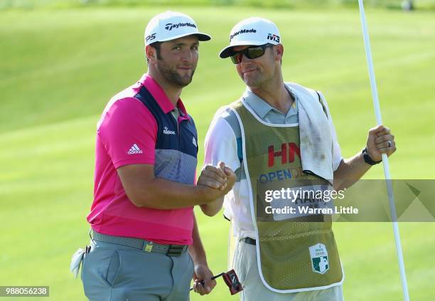 Jon Rahm of Spain celebrates a birdie with his caddie Adam Hayes on the 18th green during the third round of the HNA Open de France at Le Golf...