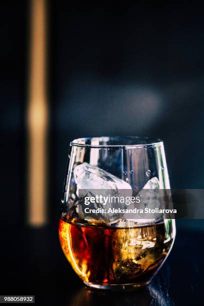 a glass of whisky with ice. - cognac glass stock pictures, royalty-free photos & images
