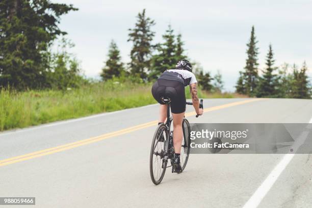 cyclist rides along a rural highway - south central alaska stock pictures, royalty-free photos & images