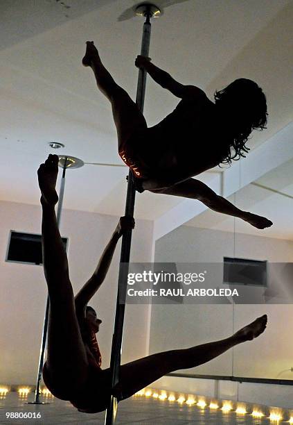 Monica Sierra and Zully Ochoa perform their pole dancing routine at a Pole Dance academy in Medellin, Antioquia department, Colombia on April 27,...