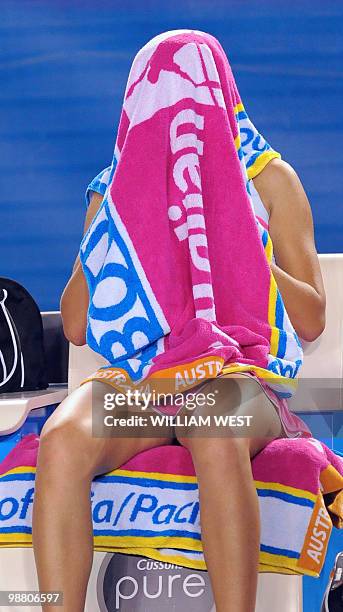 Victoria Azarenka of Belarus sits with a towel over her head between games against Vera Zvonareva of Russia in their women's singles fourth round...