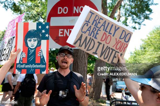 An anti-abortion activist is blocked by demonstrators during a protests gainst the separation of immigrant families, on June 30, 2018 in Washington,...