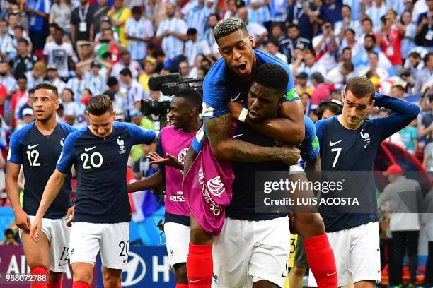 France's defender Samuel Umtiti gives a piggy back ride to France's defender Presnel Kimpembe as they celebrate their win at the end of the Russia...