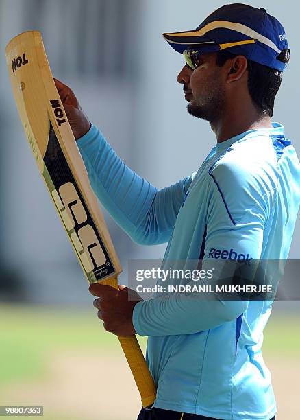 Sri Lankan cricketer Kumar Sangakkara inspects his bat during a training session at the Georgetown Cricket Club ahead of their match of the ICC World...