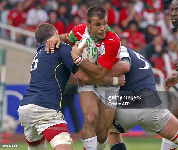 Biarritz' Arnaud Mignardi is stopped by Munster's Brian O'Driscoll and Alan Quinlan during the European cup rugby union semi-final match Biarritz vs....