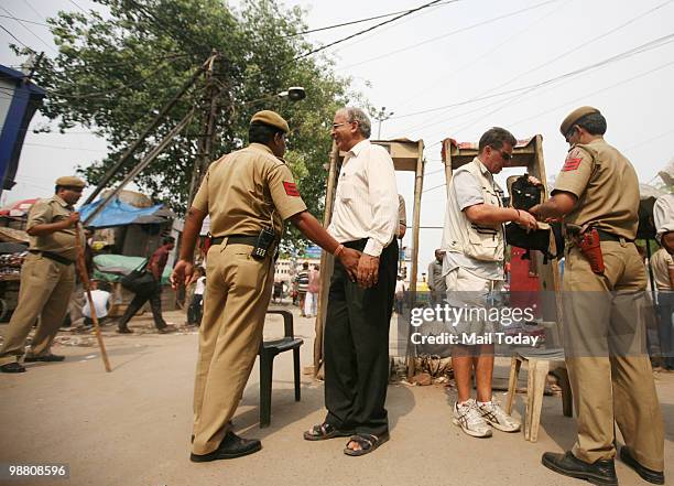 Policemen check people at the Paharganj market in New Delhi on May 2, 2010. The capital remained on high alert for the second successive day...