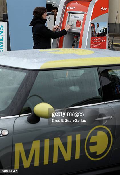 Visitor tries out the keypad of a charging column at an outdoor presentation of electric cars by auto manufacturers Smart, Volkswagen, Mini and Opel...