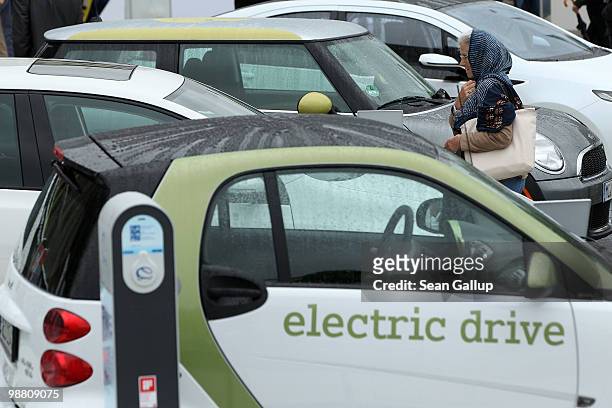 Visitor looks at an outdoor presentation of electric cars by auto manufacturers Smart, Volkswagen, Mini and Opel as part of the German government's...