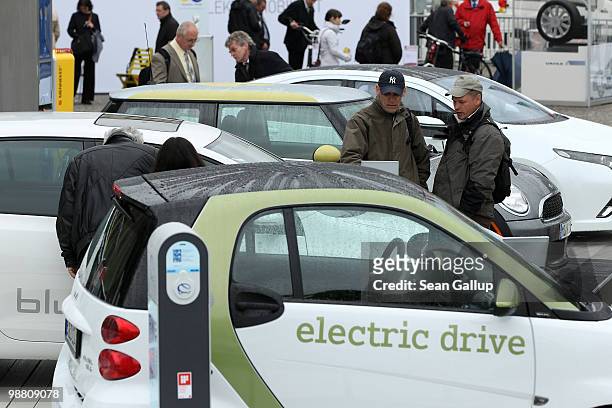 Visitors look at an outdoor presentation of electric cars by auto manufacturers Smart, Volkswagen, Mini and Opel as part of the German government's...
