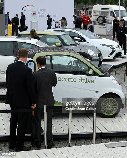 Visitors look at an outdoor presentation of electric cars by auto manufacturers Smart, Volkswagen, Mini and Opel as part of the German government's...