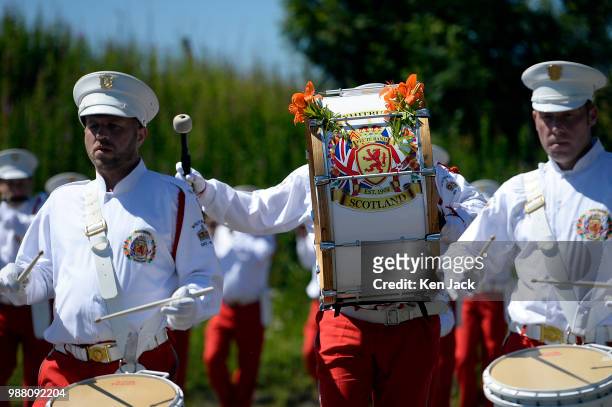 The bass drum is adorned with orange lilies as one of the many Orange Order marching bands taking part in a rally and parade marches through the...