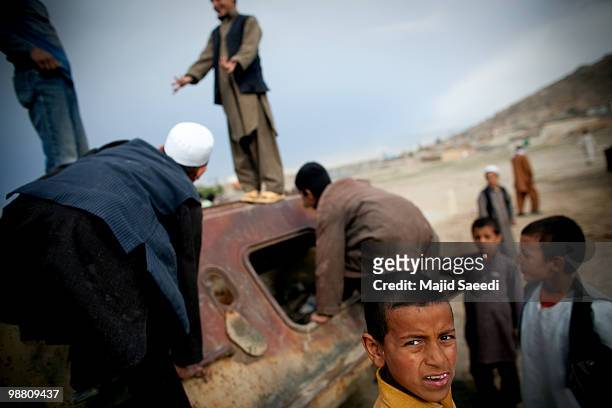 Afghan boys on the outskirts of Kabul play inside a destroyed tank left over from the 1979-1989 Russian invasion on May 2, 2010 in Afghanistan. "This...