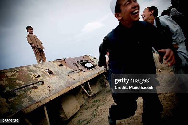 Afghan boys on the outskirts of Kabul play inside a destroyed tank left over from the 1979-1989 Russian invasion on May 2, 2010 in Afghanistan. "This...