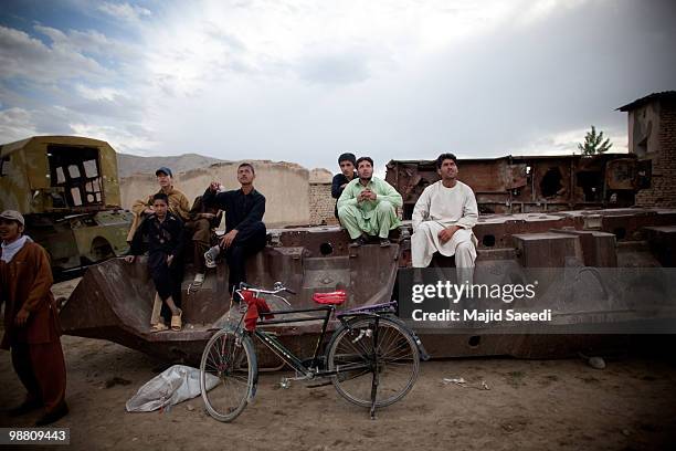 Afghan boys on the outskirts of Kabul play inside a destroyed tank left over from the 1979-1989 Russian invasion on May 2, 2010 in Afghanistan. "This...