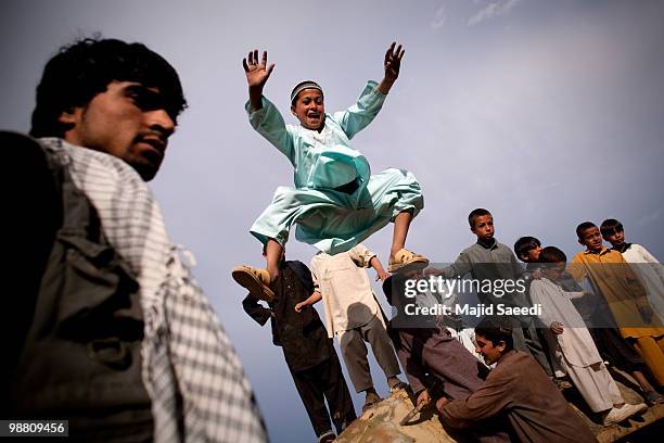 Afghan boys on the outskirts of Kabul play inside a destroyed tank left over from the 1979-1989 Russian invasion on May 2, 2010 in Afghanistan. "This...