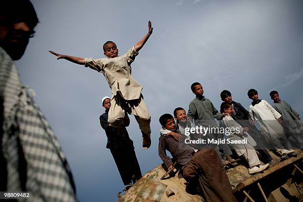 Afghan boys on the outskirts of Kabul play inside a destroyed tank left over from the 1979-1989 Russian invasion on May 2, 2010 in Afghanistan. "This...