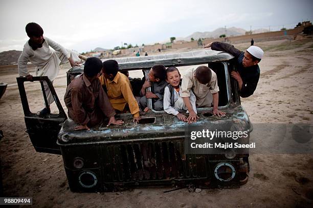 Afghan boys on the outskirts of Kabul play inside a destroyed tank left over from the 1979-1989 Russian invasion on May 2, 2010 in Afghanistan. "This...