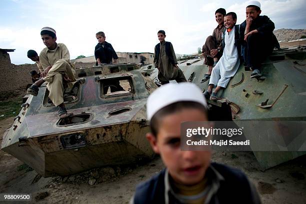 Afghan boys on the outskirts of Kabul play inside a destroyed tank left over from the 1979-1989 Russian invasion on May 2, 2010 in Afghanistan. "This...