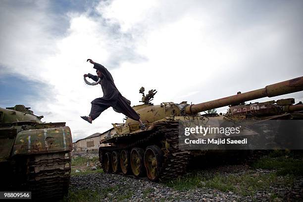 Former member of the Mujahideen jumpsover Soviet-era tanks currently held in a junk scrapyard on May 2 south of Kabul. These tanks have changed hands...