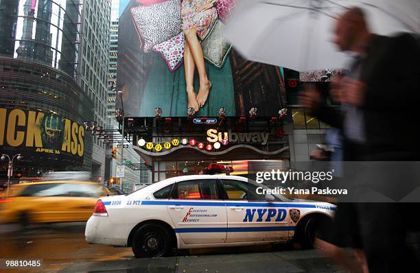 Pedestrians walk past the corner of 42nd Street and 7th Avenue in Times Square May 3, 2010 in New York City. The area resumed normal operations, with...