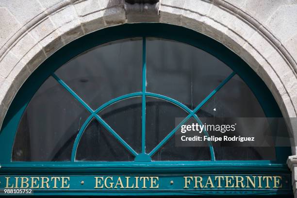 the motto "liberte, egalite, fraternite" on the door of the city hall, town of quimper, departament - egalite stock pictures, royalty-free photos & images