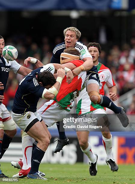 Imanol Harinordoquy of Biarritz, wearing a nose protector, is tackled by Alan Quinlan and Jean de Villiers during the Heineken Cup semi final match...