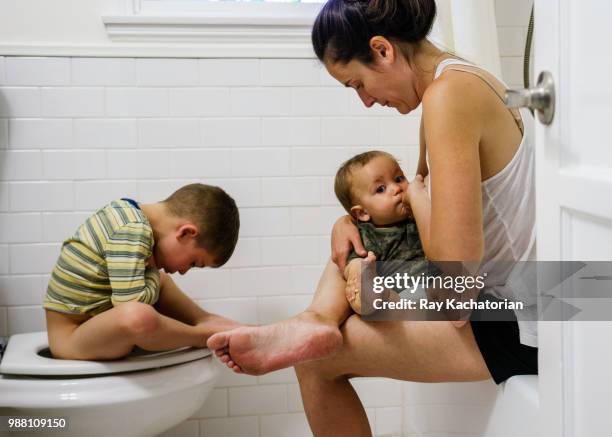 mother with children in bathroom - allattare al seno bambino foto e immagini stock