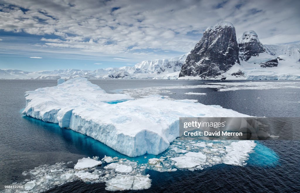 Clouds over iceberg floating on water, Antarctica