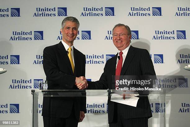Glenn Tilton , chairman, president and CEO of United Airlines, and Jeff Smisek, chairman, president and CEO of Continental Airlines, shake hands...
