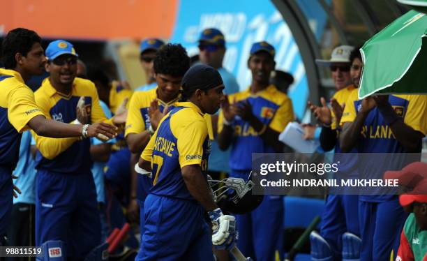 Sri Lankan cricketers congratulate teammate Mahela Jayawardene as he walks back after his innings against Zimbabwe during their ICC T20 World Cup...